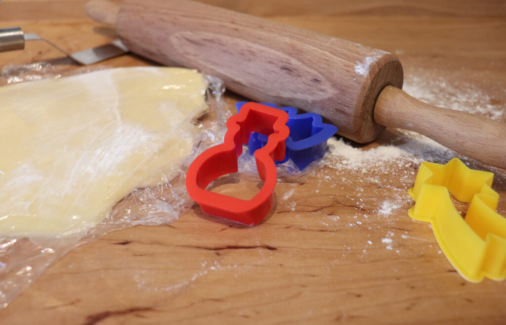 Wellholz, ausgerollter Teig und Ausstecher